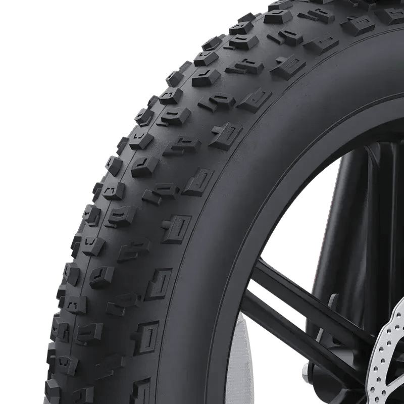Close-up of 20-inch wide knobby tire for mountain bike with black spokes and disc brake